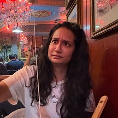 Sana looking alarmed at a very long cheese pull from a fondue pot